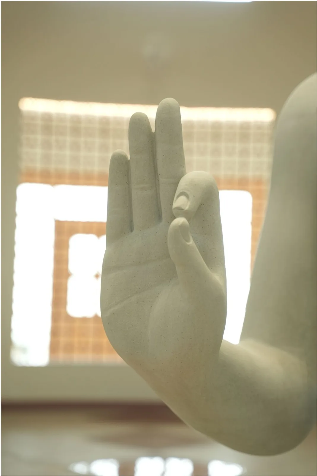Close-up of the raised right hand of the Buddha statue